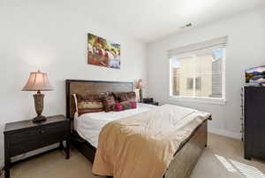 Bedroom featuring light colored carpet and baseboards