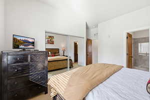 Bedroom with light carpet, a closet, and ensuite bath