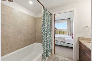 Full bathroom with vanity, ensuite bathroom, shower / bath combination with curtain, light tile patterned floors, and recessed lighting