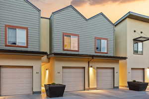 View of front of house with stucco siding, a garage, and driveway