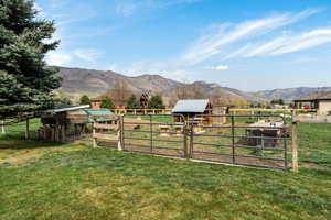 View of yard with an outdoor structure, a mountain view, and a view of rural / pastoral area