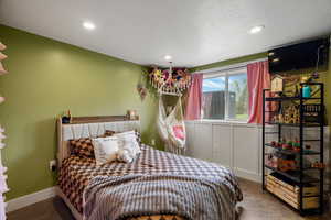 Bedroom with recessed lighting, a textured ceiling, and concrete floors