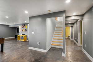 Staircase with concrete flooring and recessed lighting