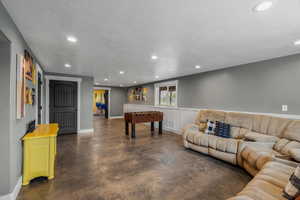 Game room with concrete floors, recessed lighting, and a textured ceiling