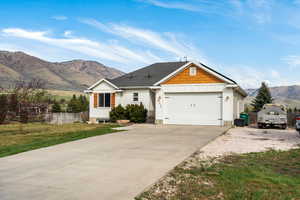 View of front of house with board and batten siding, a mountain view, driveway, and a garage