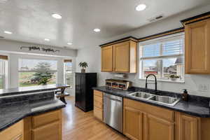 Kitchen with stainless steel dishwasher, light wood-style flooring, recessed lighting, and wood finish cabinets