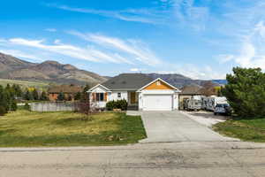 View of front facade with a mountain view, concrete driveway, and an attached garage