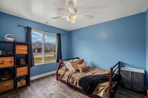 Bedroom with dark wood-style floors, a mountain view, and a ceiling fan