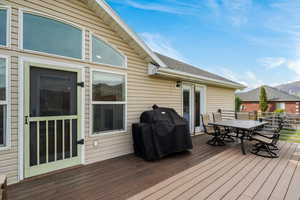 Wooden terrace with outdoor dining space and grilling area