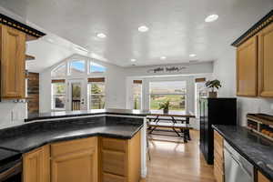 Kitchen featuring a peninsula, light wood-type flooring, plenty of natural light, dishwasher, and recessed lighting