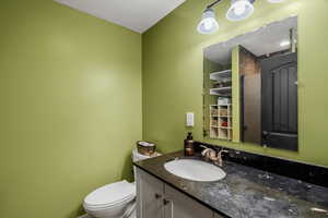 Half bath with vanity and a textured ceiling