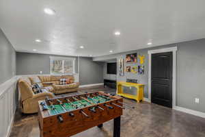 Playroom featuring finished concrete flooring, recessed lighting, and a textured ceiling