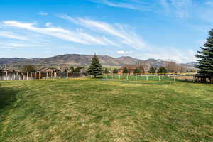 Fenced yard featuring a mountain view and a view of countryside