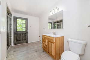 Full bathroom with vanity, wood tiled floors, plenty of natural light, a stall shower, and crown molding