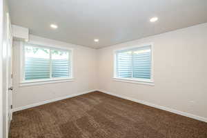 Empty room featuring dark carpet and recessed lighting