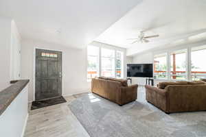 Living area featuring baseboards and ceiling fan