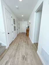 Hall with light wood-style flooring and baseboards