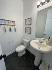 Half bath with toilet and baseboards
