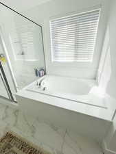 Full bath with a stall shower, a bath, and marble finish floors