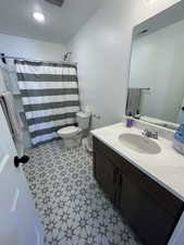 Full bath with a shower with curtain and vanity