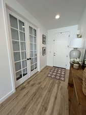 Foyer with dark wood finished floors, french doors, and recessed lighting