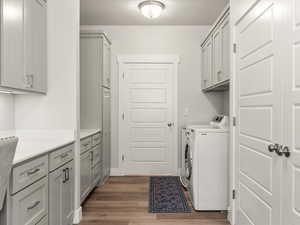 Laundry room featuring cabinet space, washer and clothes dryer, and dark wood-style floors