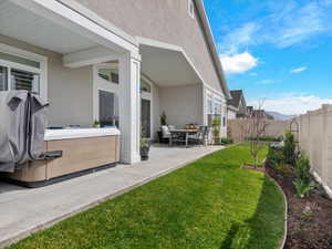 Fenced backyard featuring a patio area and a hot tub