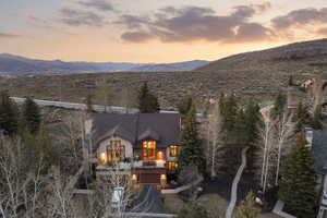 Back of property at dusk featuring a balcony and a mountain view