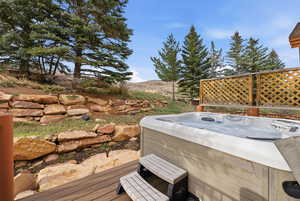 Wooden terrace featuring a hot tub