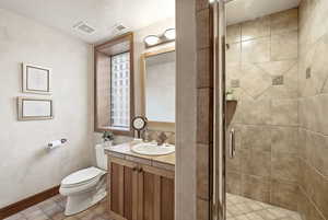 Bathroom featuring a stall shower, vanity, and light tile patterned floors