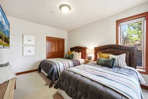 Carpeted bedroom with baseboards and a closet