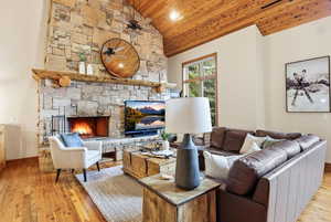 Living room featuring a fireplace, light wood-type flooring, a vaulted wood ceiling, a ceiling fan, and recessed lighting