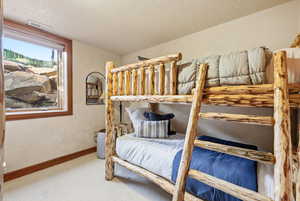 Bedroom with a textured ceiling and light carpet