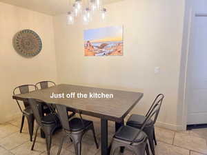 Dining room with light tile patterned floors just off the kitchen.