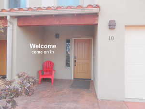 View of exterior entry featuring a tiled roof and stucco siding