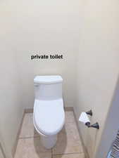 Master ensuite bathroom with baseboards and light tile patterned floors