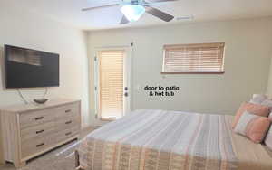 Master bedroom with light colored carpet and ceiling fan. opens up to Hot Tub.