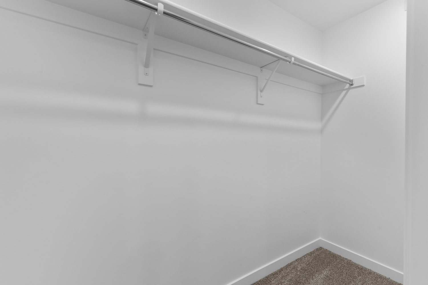 Walk in closet featuring dark carpet