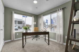 Office with light colored carpet and baseboards
