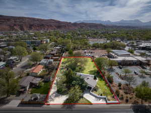 Aerial perspective of suburban area featuring property parcel outlined and a mountainous background