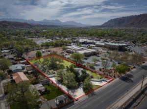 Aerial perspective of suburban area with property boundaries highlighted and a mountainous background