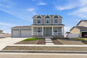 View of front of house with a gate, covered porch, an attached garage, and concrete driveway