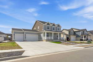 View of front of home featuring a porch, an attached garage, concrete driveway, and a residential view