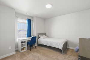 Bedroom with light carpet and baseboards