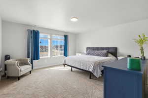 Bedroom with light colored carpet and baseboards