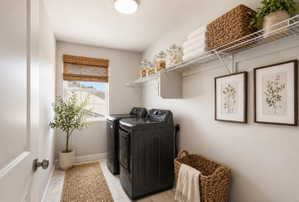 Laundry room featuring baseboards and washing machine and clothes dryer