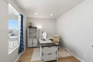 Office featuring light wood-style flooring and recessed lighting