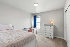 Bedroom with light carpet and a closet