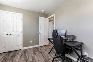 Home office with wood finished floors and a textured ceiling