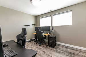 Home office with light wood finished floors and baseboards